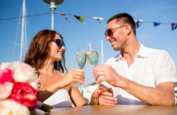 Sorrindo casal bebendo champanhe no café Imagens De Bancos De Imagens