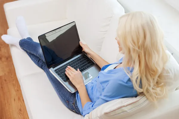 Mulher sorridente com computador portátil em casa — Fotografia de Stock