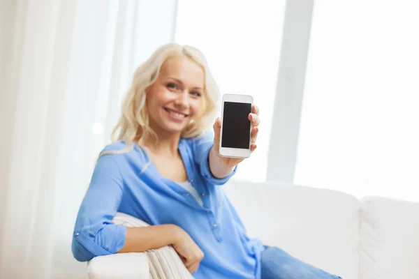 Lachende vrouw met smartphone thuis — Stockfoto