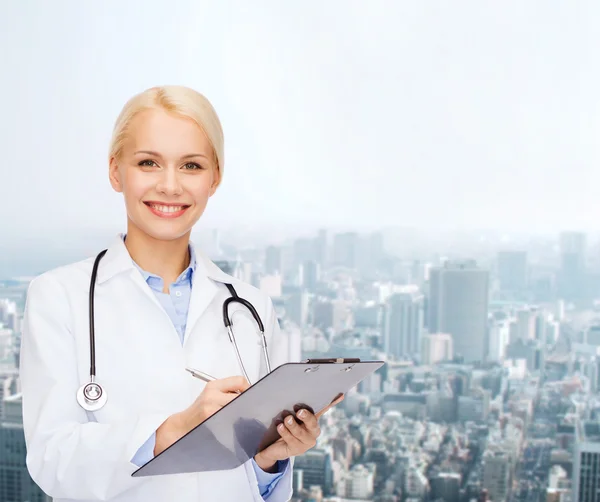 Smiling female doctor with clipboard — Stock Photo, Image