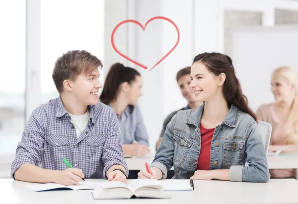 Due adolescenti con quaderni e libro a scuola — Foto Stock