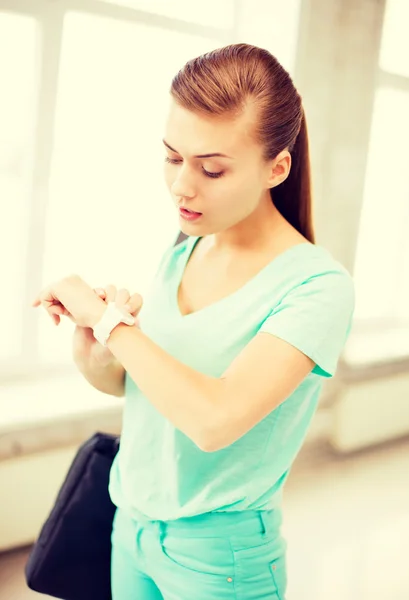 Chica estudiante sorprendido mirando reloj de pulsera — Foto de Stock