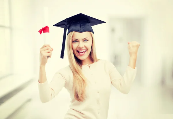 Estudiante en gorra de graduación con certificado — Foto de Stock