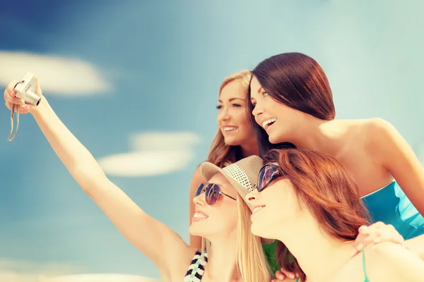 Smiling girls taking photo in cafe on the beach — Stock Photo, Image