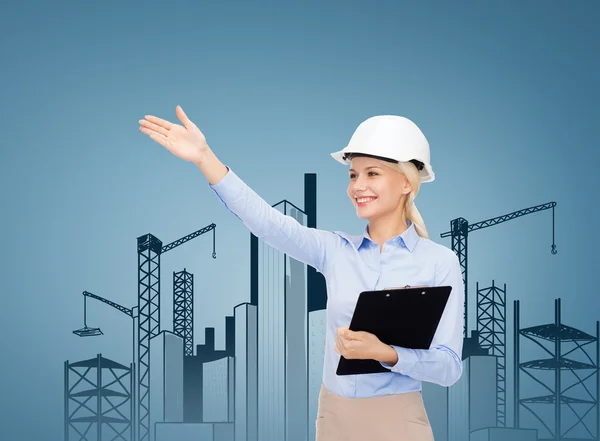 Smiling businesswoman in helmet with clipboard — Stock Photo, Image