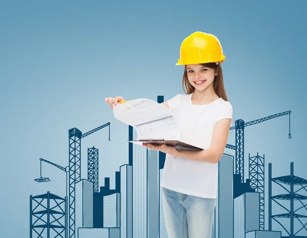 Niña sonriente en hardhat con portapapeles — Foto de Stock