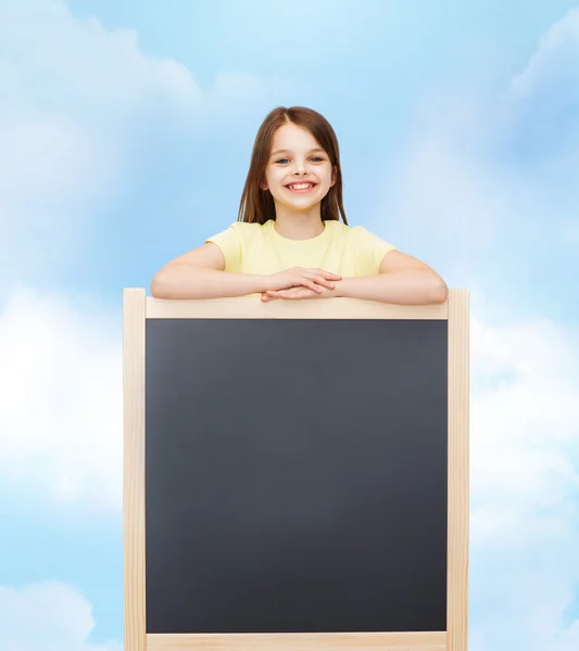 Happy little girl with blank blackboard — Stock Photo, Image