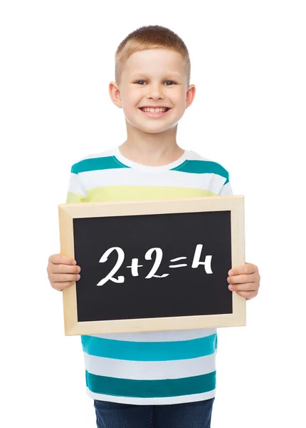 Smiling little boy with blank blackboard Royalty Free Stock Images