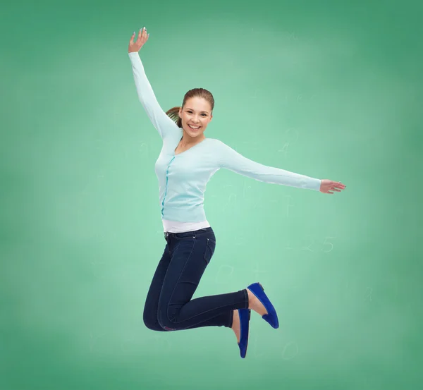 Uśmiechnięta młoda kobieta skacząca w powietrzu — Zdjęcie stockowe