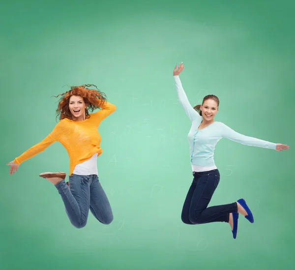 Lachende jonge vrouwen springen in de lucht — Stockfoto