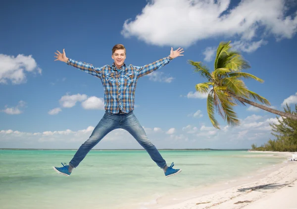 Smiling young man jumping in air — Stock Photo, Image