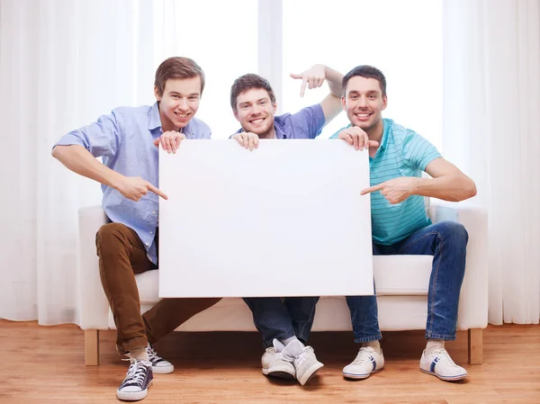 Happy male friends with blank white board at home — Stock Photo, Image