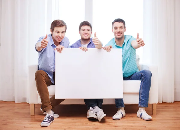 Amigos masculinos felices con tablero blanco en blanco — Foto de Stock