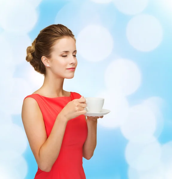 Donna sorridente in abito rosso con tazza di caffè — Foto Stock