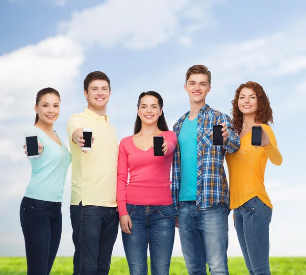 Grupp leende tonåringar med smartphones — Stockfoto