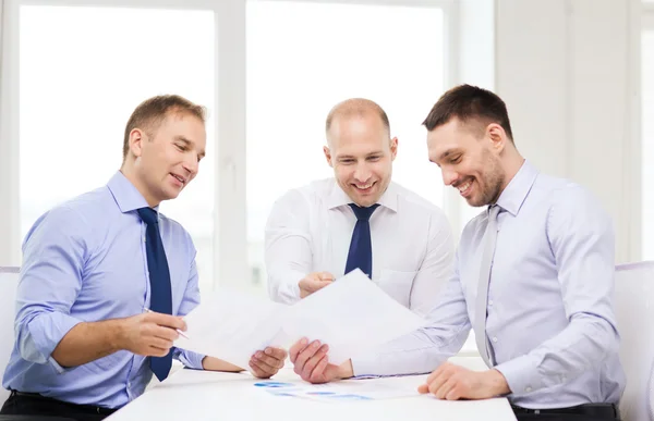 Lächelnde Geschäftsleute mit Papieren im Amt — Stockfoto