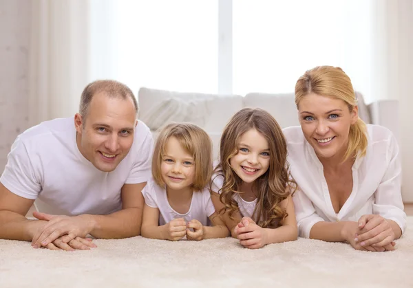 Parents and two girls lying on floor at home — Stock Photo, Image