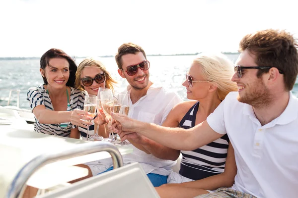 Улыбающиеся друзья с бокалами шампанского на яхте — стоковое фото