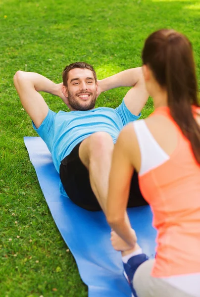 Sonriente hombre haciendo ejercicios en la estera al aire libre —  Fotos de Stock