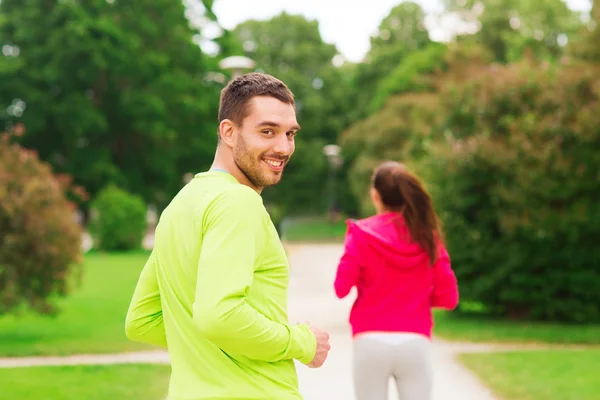 Smiling couple running outdoors — Stock Photo, Image