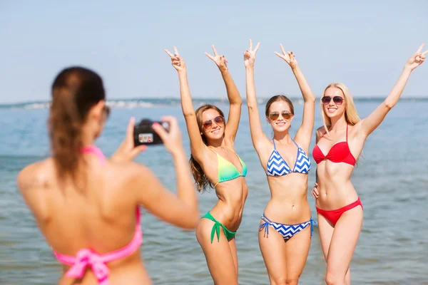 Groep van de lachende vrouw fotograferen op strand Stockfoto