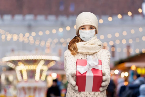 Fille en masque avec boîte cadeau sur le marché de Noël — Photo