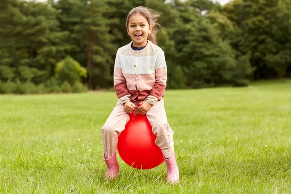 Menina feliz saltando na bola funil no parque — Fotografia de Stock