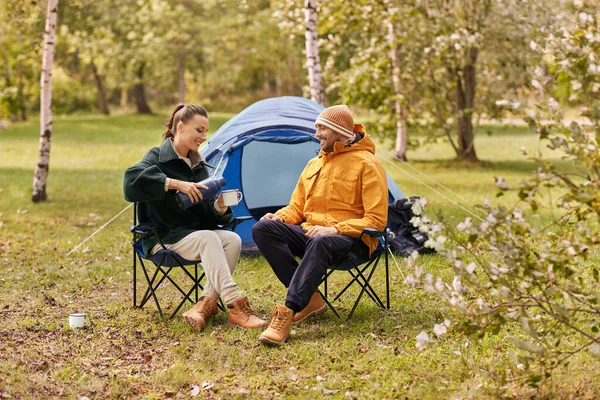 テントキャンプで魔法瓶がお茶を注ぐ幸せなカップル — ストック写真