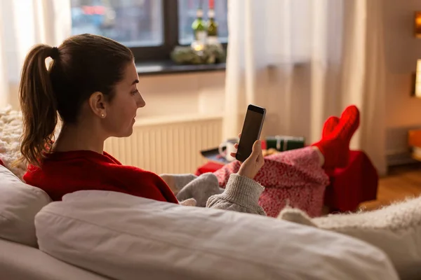Frau nutzt an Weihnachten Smartphone zu Hause — Stockfoto