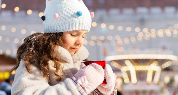 Mała dziewczynka z filiżanką herbaty na rynku Bożego Narodzenia — Zdjęcie stockowe