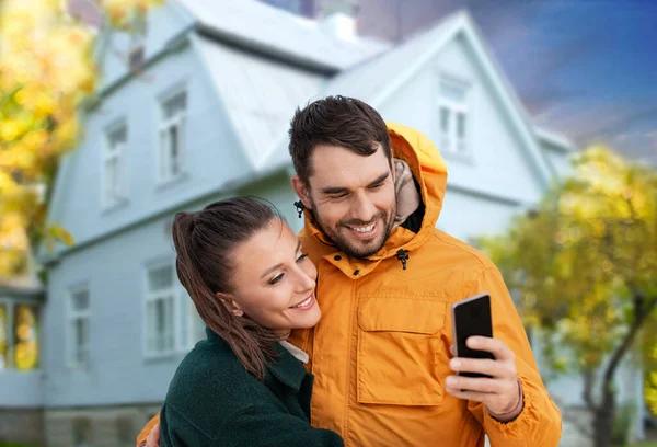 Pareja tomando selfie sobre casa en otoño —  Fotos de Stock