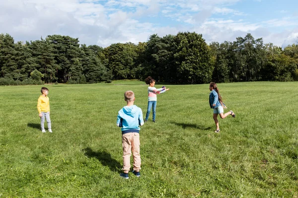 Щасливі діти грають з літаючим диском у парку — стокове фото