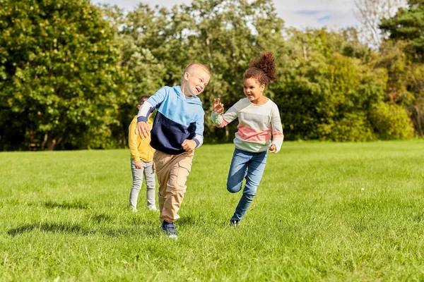Gelukkige kinderen spelen en lopen in het park — Stockfoto