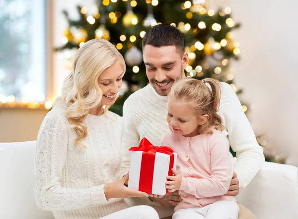 Famille heureuse à la maison avec boîte cadeau de Noël — Photo