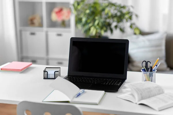Laptop, notebook e livro na mesa no escritório em casa — Fotografia de Stock