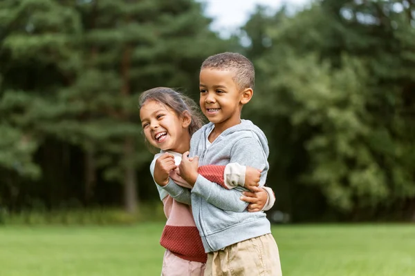 Happy little boy and girl hugging at park — Stock Photo, Image