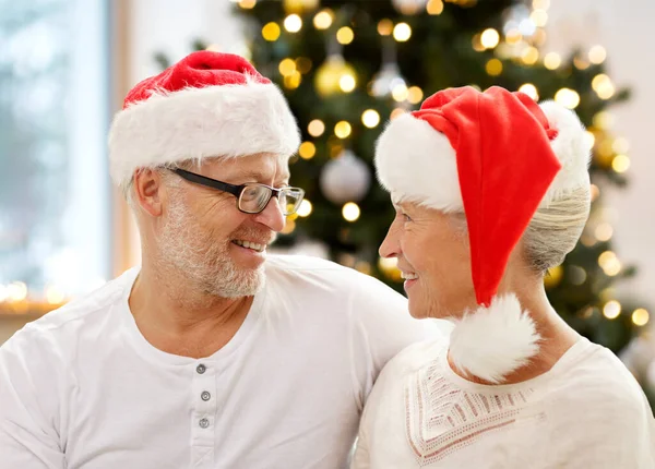 Felice coppia di anziani in cappelli Babbo Natale helper a casa — Foto Stock