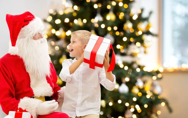 Uśmiechnięty chłopiec z Mikołajem i prezenty w domu — Zdjęcie stockowe