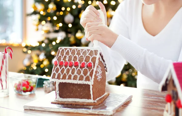 Primer plano de la mujer con la casa de jengibre de Navidad —  Fotos de Stock