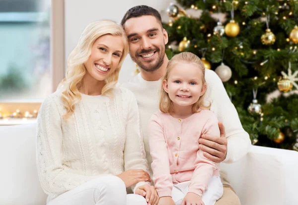 Счастливая семья дома над рождественской елкой — стоковое фото