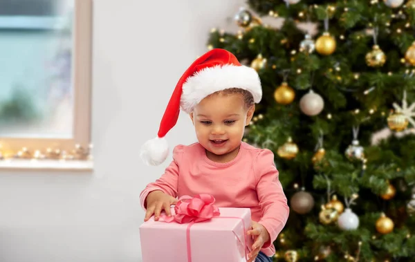 Szczęśliwa dziewczynka z prezentem świątecznym w domu — Zdjęcie stockowe