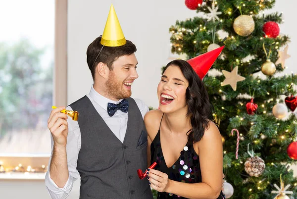 Szczęśliwy para z party blowers na Boże Narodzenie — Zdjęcie stockowe