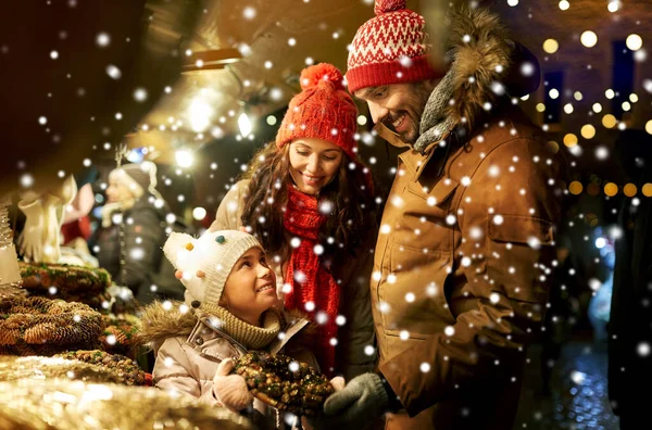 Gelukkig familie kopen krans op kerstmarkt — Stockfoto