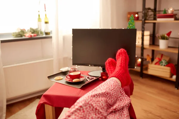 Ноги в красных носках на столе дома на Рождество — стоковое фото