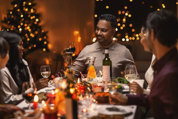 Ευτυχισμένοι φίλοι πίνουν κρασί στο Χριστουγεννιάτικο πάρτι — Φωτογραφία Αρχείου