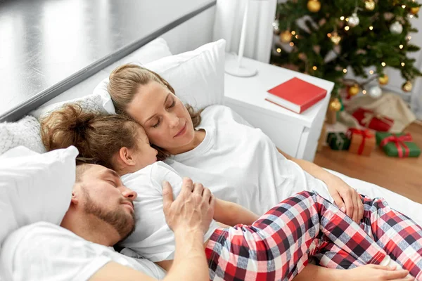 圣诞节早上快乐的一家人睡在床上 — 图库照片