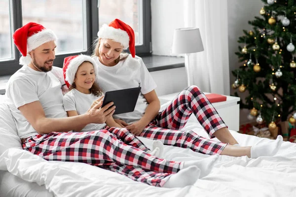 圣诞节快乐的家庭，床上放着平板电脑 — 图库照片