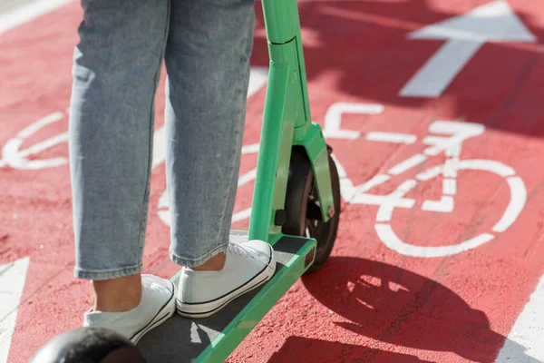 Kvinna ridning skoter längs cykelväg i staden — Stockfoto