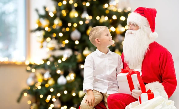 Leende pojke med tomte klor och presenter hemma — Stockfoto