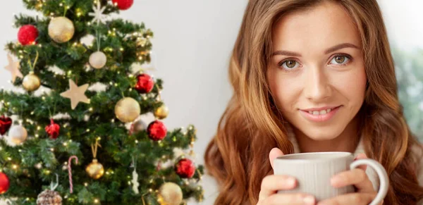 Усміхнена жінка п'є каву вдома на Різдво — стокове фото
